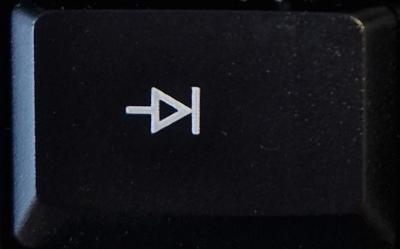 Die Tabulator-Taste auf einer schwarzen Computer-Tastatur: weißer Pfeil zeigt nach rechts auf senkrechten Strich