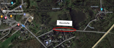 Satellit Aufnahme Google Maps vom Ortsteil Brüggen Umkreis Laarer Bach: Ansicht auf Dächer von Gebäuden, Straßen in grau und grüner dichter Baum- und Strauchbewuchs von oben und grüne Wiesen, mittig See, Straßennamen und andere Bezeichnungen in weißer Schrift, diverse Symobole in verschiedenen Farben für z.B. Restaurants oder Parkplätze, mittig rotes Oval, darüber weißes Rechteck mit schwarzer Schrift „Baustelle“