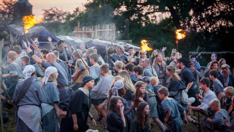 Laufende mittelalterliche Menschenmenge In Dorf mit Fackeln und Speeren