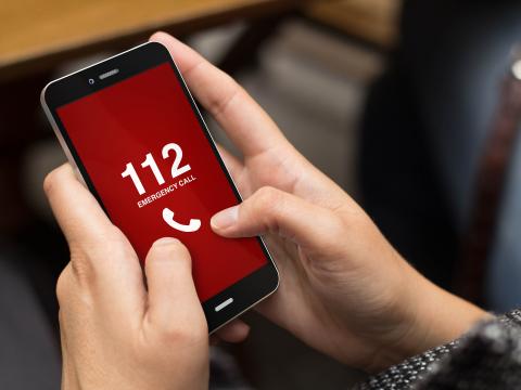 Handy in beiden Händen mit roten Bildschirum und Notruf 112 