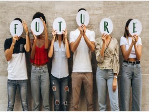 Sechs junger Menschen unterschiedlich gekleidet aufgereiht vor Wand halten weiße, kreisförmige Schilder mit schwarzen Buchstaben, die das Wort "Future" ergeben, vor ihr Gesicht